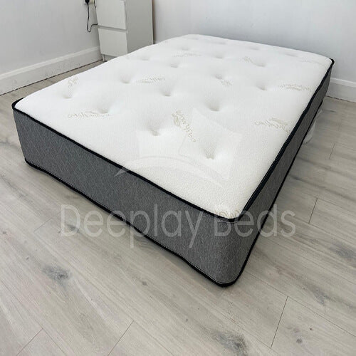 Gray and white mattress on a wooden floor with 'Deeplyy Beds' branding.