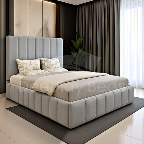 Gray upholstered bed with tufted design in a modern bedroom setting.
