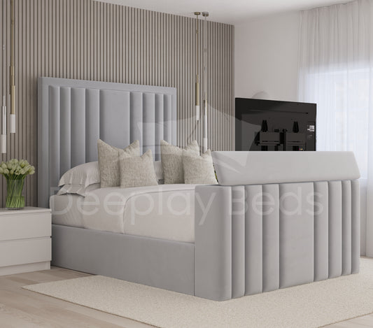 Aethelwulf Grey upholstered ottoman storage TV bed frame with panelled headboard and integrated footboard, TV in modern bedroom.