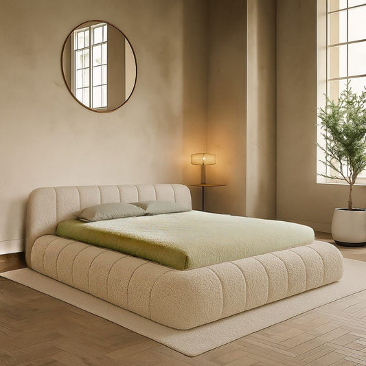 Beige upholstered bed with green blanket in a modern bedroom setting.