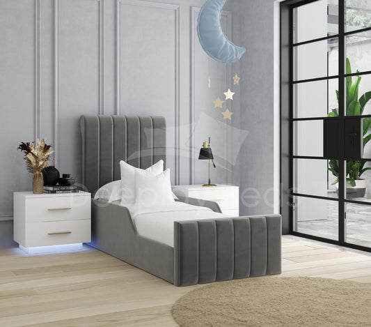 Gray upholstered bed in a modern bedroom with white walls and decorative elements.