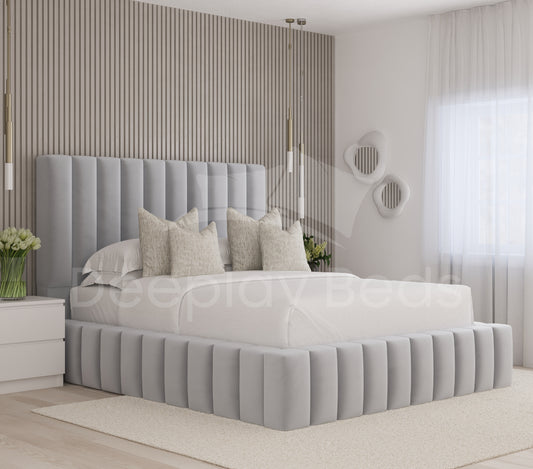 Modern bedroom with a gray upholstered bed and decorative pillows.
