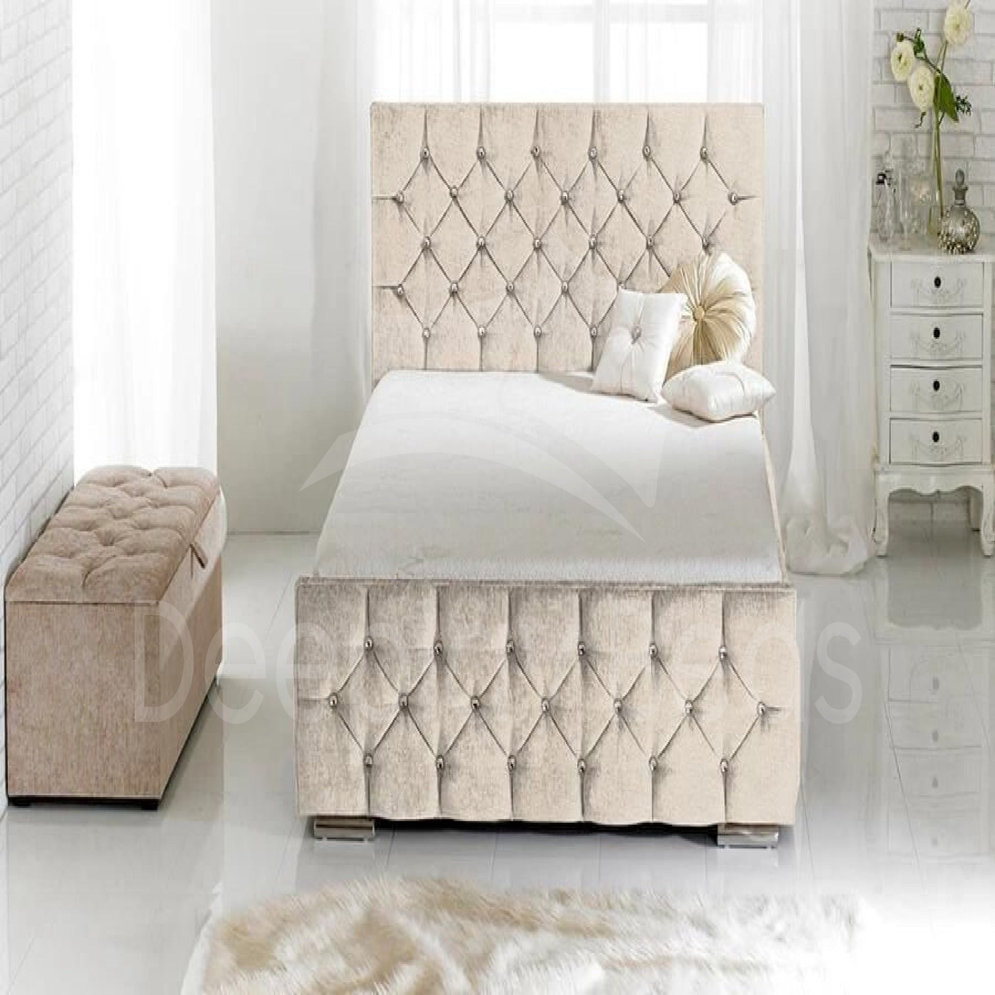 Beige tufted bed with matching ottoman in a bright bedroom setting