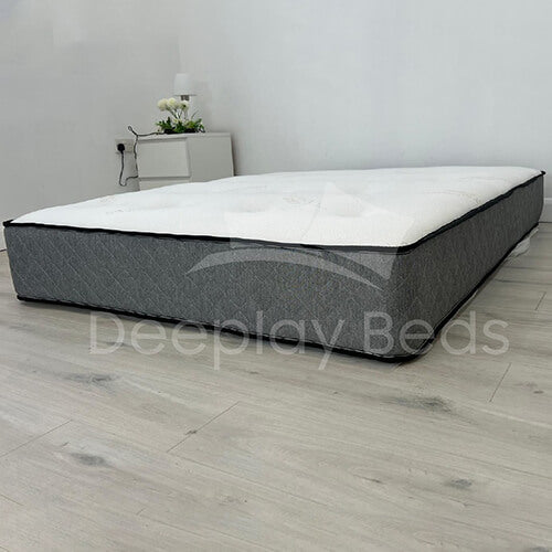 Gray and white mattress on a wooden floor with 'Deeplyy Beds' branding.