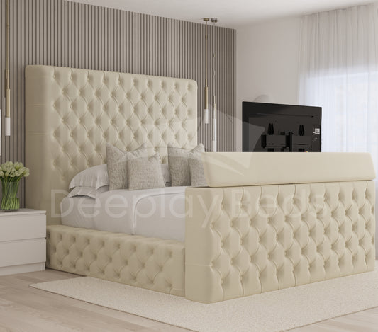 Beige tufted bed in a modern bedroom setting with a television in the background.